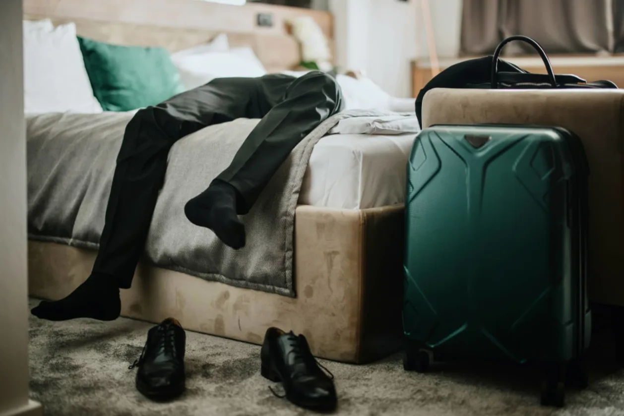 business man lying on bed with traveler's tummy
